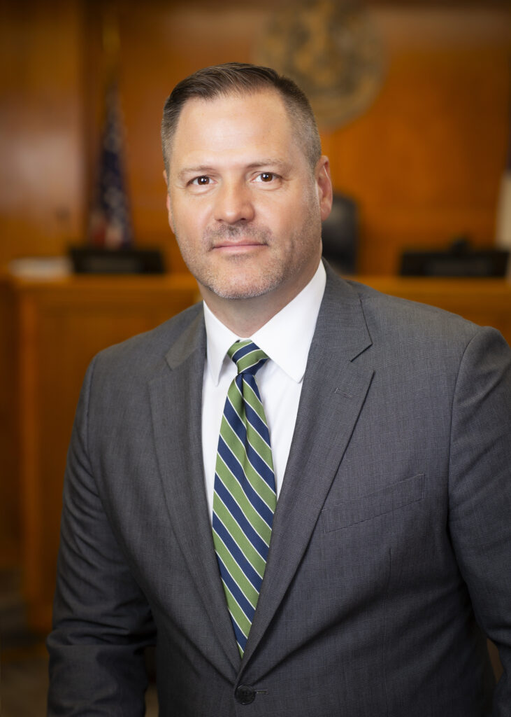 Man in gray suit inside a court room.