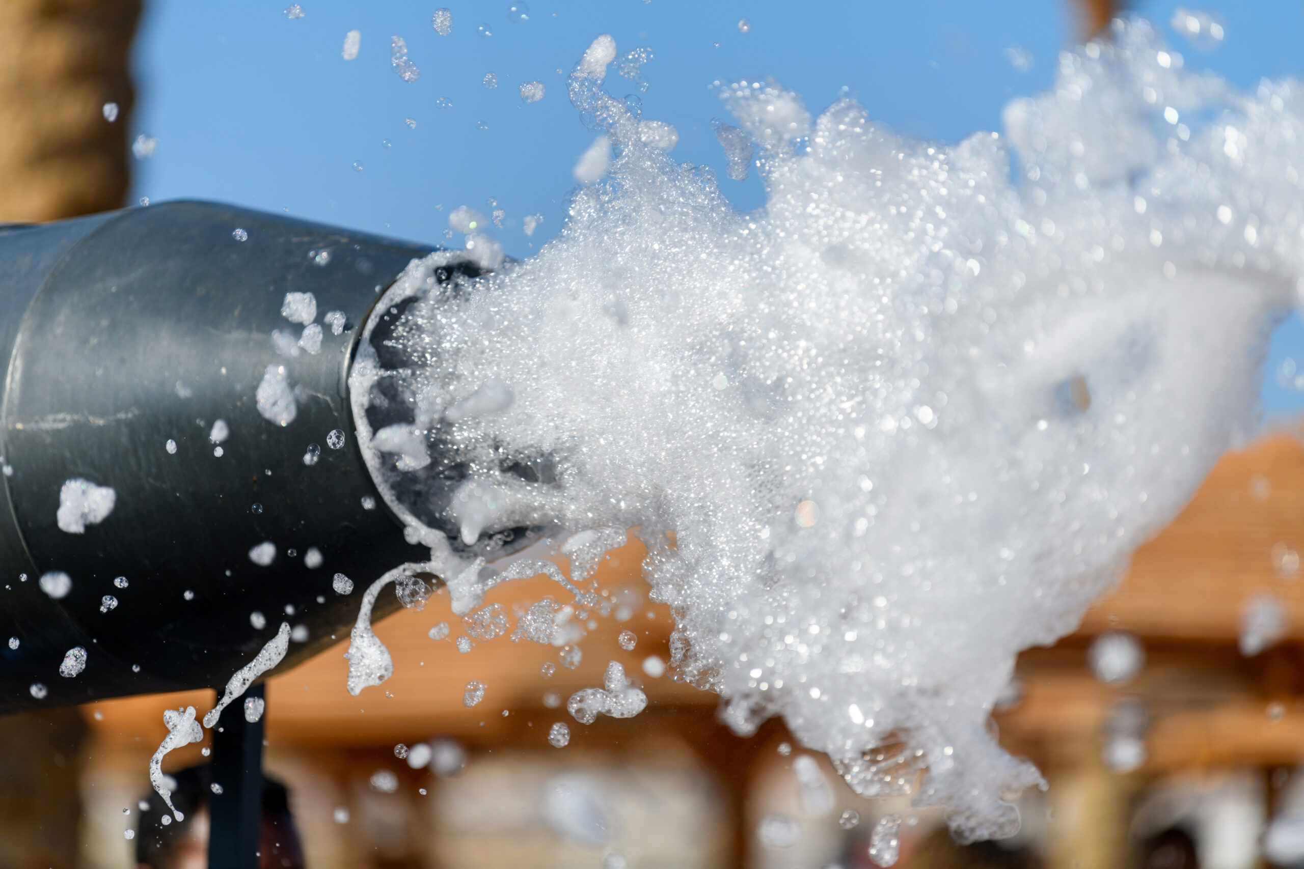 Close-up of a hose splashing foams.