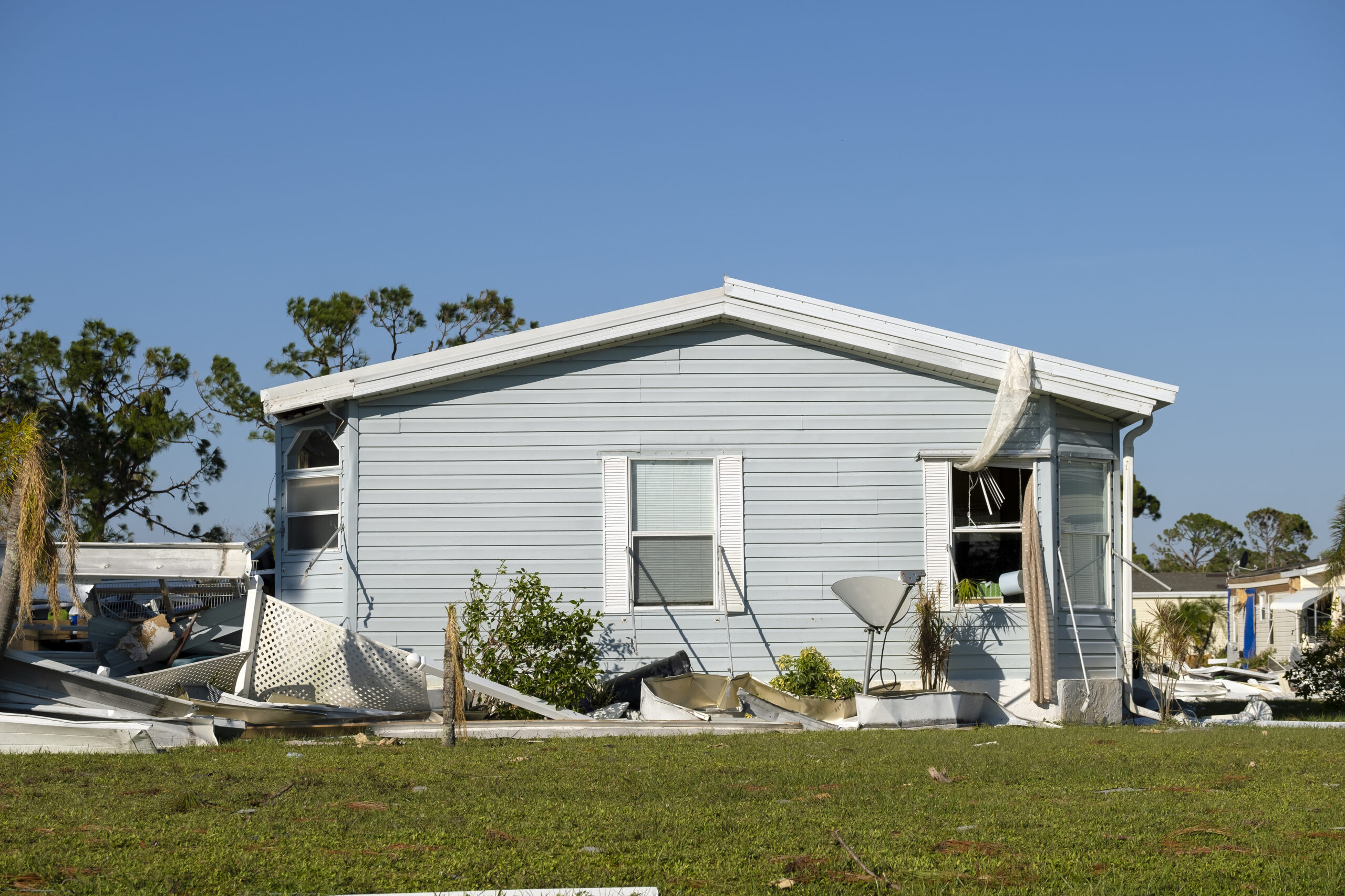 Collapsed and damaged mobile homes after hurricane swept through Florida residential area.