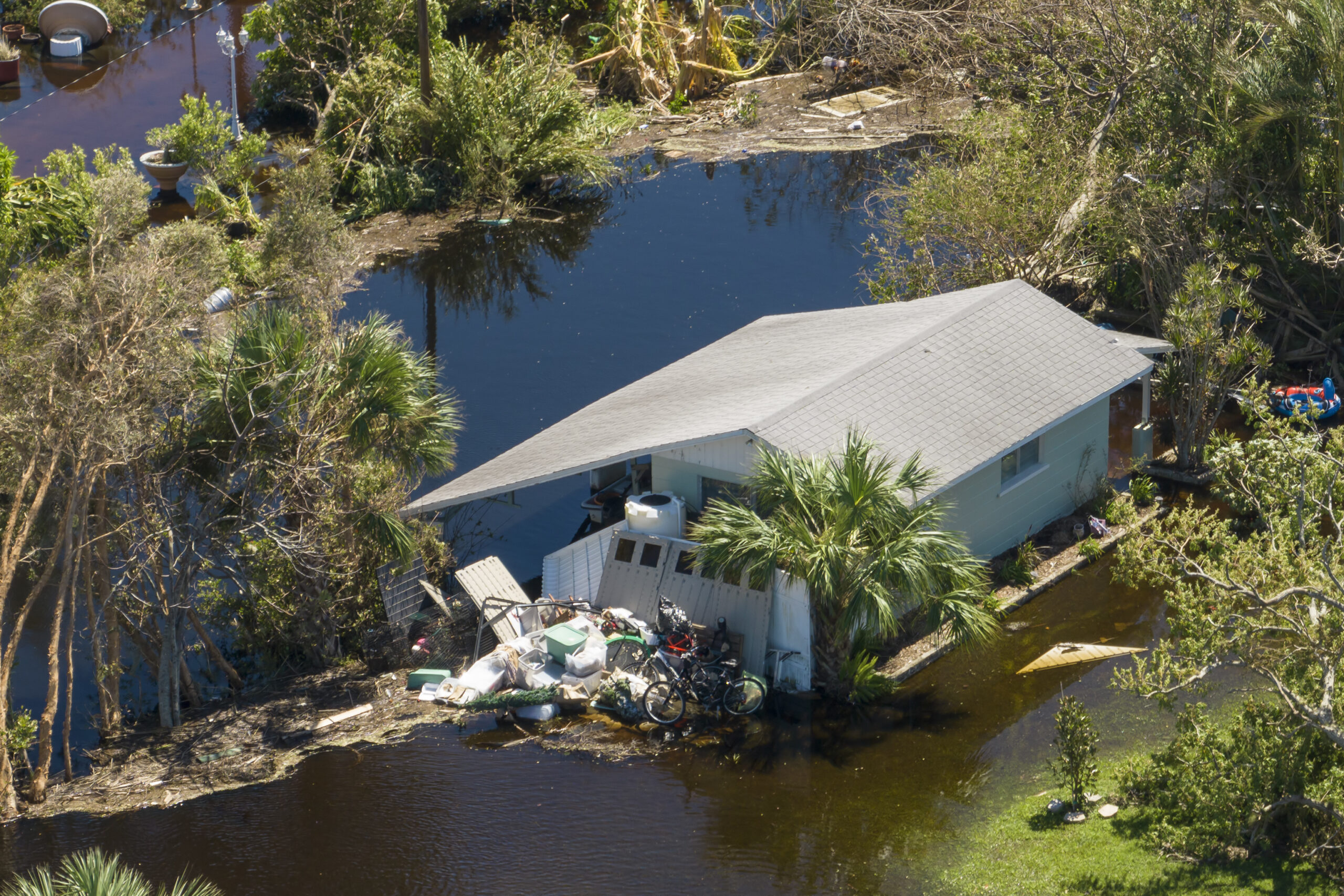 Heavy flood with high water surrounding residential house after hurricane rainfall.